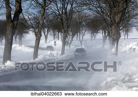 Stock Image - "Cars in snow flurry, Kuhlungsborn, Mecklenburg, Germany, Europe". Fotosearch