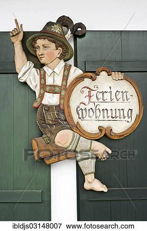 "Carved wooden figure with a sign """"Ferienwohnung"""", German for holiday home, Garmisch-Partenkirchen, Upper Bavaria, Bavaria, Germany, Europe" View Large Photo Image Stock Photo - "Carved wooden figure with a sign """"Ferienwohnung"""", German for holiday home, Garmisch-Partenkirchen, Upper Bavaria, Bavaria, Germany, Europe". Fotosearch