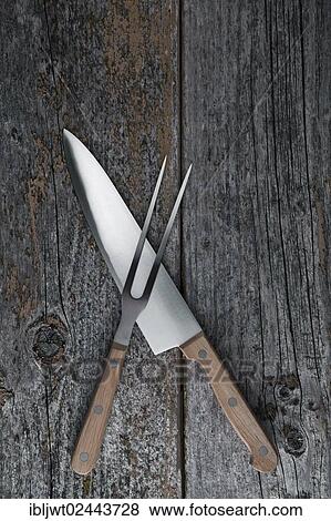 Stock Photo - Carving knife and fork on a rustic wooden boards. Fotosearch