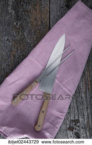 Carving knife and fork with a kitchen towel on rustic wooden boards View Large Photo Image Stock Photo - Carving knife and fork with a kitchen towel on rustic wooden boards. Fotosearch