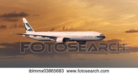 Stock Image - Cathay Pacific Boeing 777-367 ER in flight in the evening light. Fotosearch