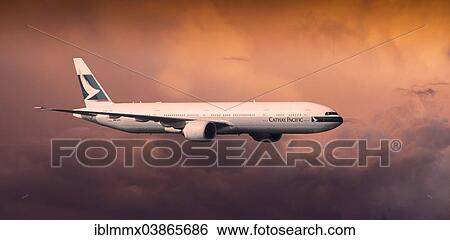 Stock Photograph - Cathay Pacific Boeing 777-367 ER in flight in the evening light. Fotosearch