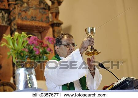 Stock Image - "Catholic worship, priest holding a chalice during the Eucharist, in a Jesuit church dating from the 18th century, San Joaquin, Caaguazu Department, Paraguay, South America". Fotosearch