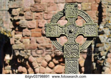 Stock Image - "Celtic cross in the ruins of the Benedictine monastery of Lindisfarne, Lindisfarne, Northumbria, England, United Kingdom, Europe". Fotosearch