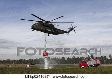 Picture - CH-53 helicopter carrying a 5000-liter water tank during an exercise, fire truck, Laupheim, Baden-Wuerttemberg, Germany, Europe. Fotosearch