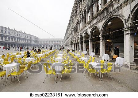 "Chairs and tables of an outdoor cafe in St Mark's Square, Procuratie buildings, San Marco quarter, Venice, Venezia, Veneto, Italy, Europe" View Large Photo Image Stock Image - "Chairs and tables of an outdoor cafe in St Mark's Square, Procuratie buildings, San Marco quarter, Venice, Venezia, Veneto, Italy, Europe". Fotosearch