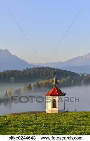 Stock Image - "Chapel on Lake Hegratsried, near Fuessen, Allgaeu, Bavaria, Germany, Europe". Fotosearch