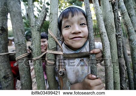 "Cheeky boy, 6, looking through a gap in a fence, in the community of Mbya-Guarani Indians, Campito, Caaguazu Department, Paraguay, South America" View Large Photo Image Stock Image - "Cheeky boy, 6, looking through a gap in a fence, in the community of Mbya-Guarani Indians, Campito, Caaguazu Department, Paraguay, South America". Fotosearch