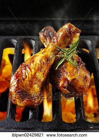 Stock Image - Chicken thighs cooking on a BBQ. Fotosearch