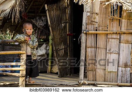 Stock Image - "Child from the Lahu people standing outside a bamboo hut, ethnic minority, hill tribe, Mae Hong Song Province, Northern Thailand, Thailand, Asia". Fotosearch