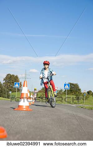 Child practicing to ride slalom on a bicycle at a traffic awareness course View Large Photo Image Stock Image - Child practicing to ride slalom on a bicycle at a traffic awareness course. Fotosearch