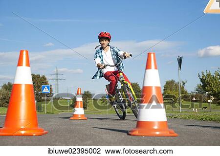 Child practicing to ride slalom on a bicycle at a traffic awareness course View Large Photo Image Stock Image - Child practicing to ride slalom on a bicycle at a traffic awareness course. Fotosearch