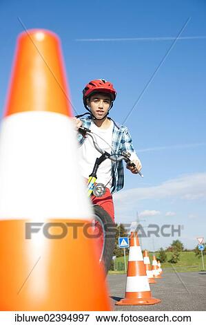 Child practicing to ride slalom on a bicycle at a traffic awareness course View Large Photo Image Stock Photo - Child practicing to ride slalom on a bicycle at a traffic awareness course. Fotosearch