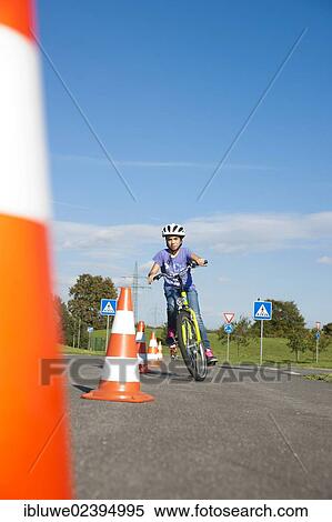 Child practicing to ride slalom on a bicycle at a traffic awareness course View Large Photo Image Stock Photography - Child practicing to ride slalom on a bicycle at a traffic awareness course. Fotosearch