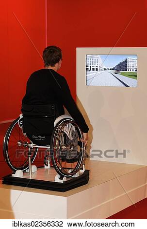 Stock Image - "Child sitting in a wheelchair in front of a screen, disability simulation, Ideenpark 2012, technology and education summit conference, Essen, Ruhr area, North Rhine-Westphalia, Germany, Europe". Fotosearch