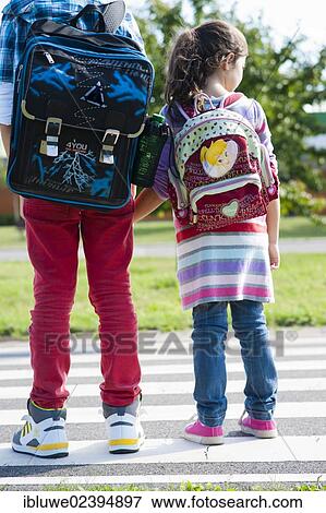Children carrying school bags on the way to school View Large Photo Image Stock Photo - Children carrying school bags on the way to school. Fotosearch