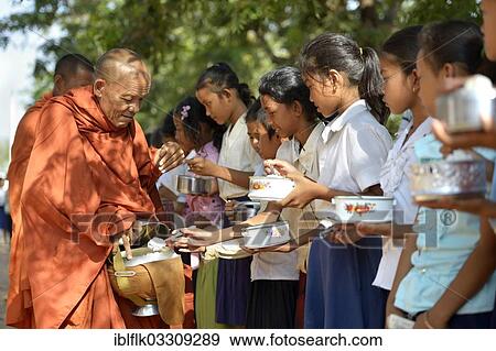 "Children donating food and money to a Buddhist monk, traditional ceremony as part of the celebration of the Cambodian New Year, Lompong Village, Bathi District, Takeo Province, Cambodia, Asia" View Large Photo Image Stock Photo - "Children donating food and money to a Buddhist monk, traditional ceremony as part of the celebration of the Cambodian New Year, Lompong Village, Bathi District, Takeo Province, Cambodia, Asia". Fotosearch
