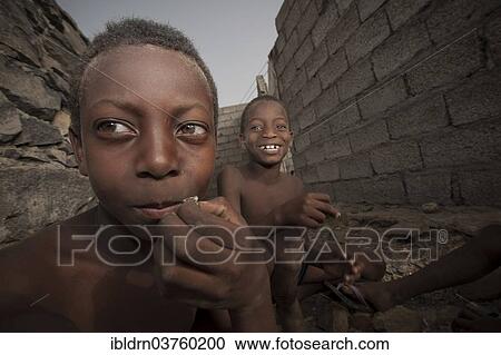 Stock Image - "Children of the Rabelados religious community eating sea snails, near Tarrafal, Santiago, Cape Verde, Africa". Fotosearch