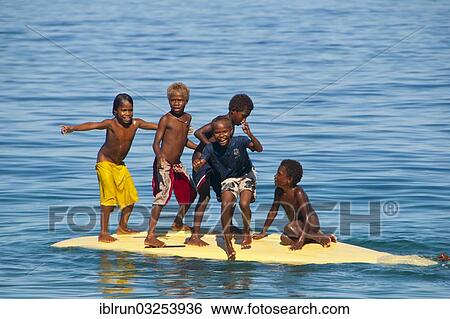 "Children playing with a surf board, Savo Island, Central Province, Solomon Islands, Oceania" View Large Photo Image Stock Photograph - "Children playing with a surf board, Savo Island, Central Province, Solomon Islands, Oceania". Fotosearch