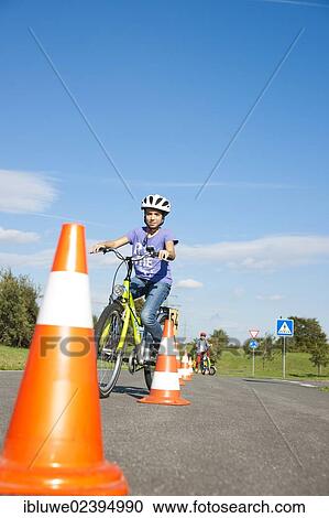 Children practicing to ride slalom on a bicycle at a traffic awareness course View Large Photo Image Stock Image - Children practicing to ride slalom on a bicycle at a traffic awareness course. Fotosearch