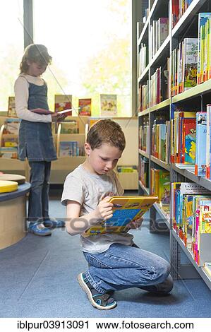 Stock Image - "Children reading books in a public library, Saxony, Germany, Europe". Fotosearch