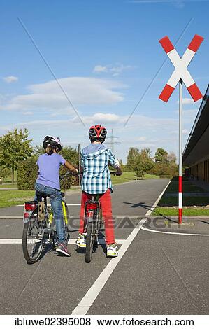 Children waiting with their bicycles in front of a railroad crossing at a traffic awareness course View Large Photo Image Stock Photo - Children waiting with their bicycles in front of a railroad crossing at a traffic awareness course. Fotosearch