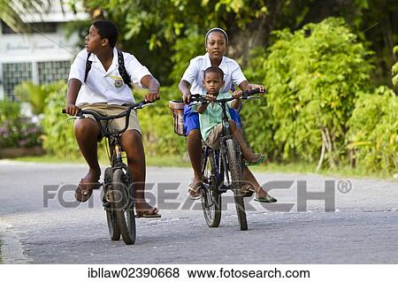 "Children wearing school uniforms while cycling, La Digue Island, Seychelles, Africa, Indian Ocean, Africa" View Large Photo Image Stock Photo - "Children wearing school uniforms while cycling, La Digue Island, Seychelles, Africa, Indian Ocean, Africa". Fotosearch