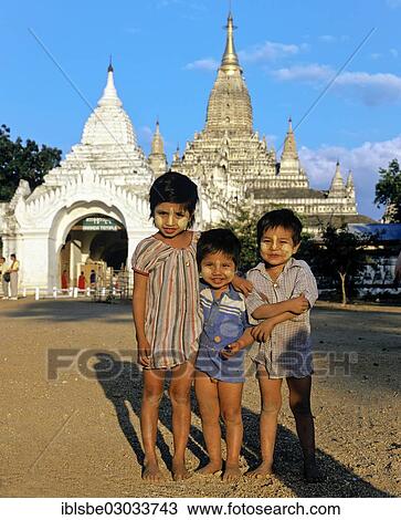 Stock Image - "Children with Thanaka paste on their faces in front of Buddhist pagodas, Ebene von Pagan, Bagan, Mandalay Division, Myanmar, Burma, Asia". Fotosearch