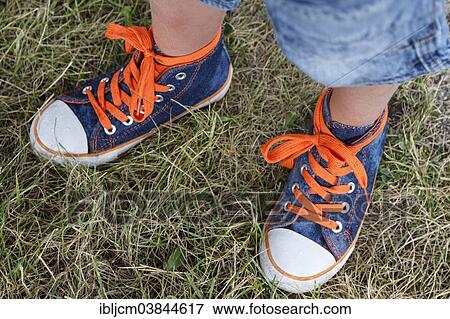 Stock Photo - Child's feet with colourful trainers. Fotosearch