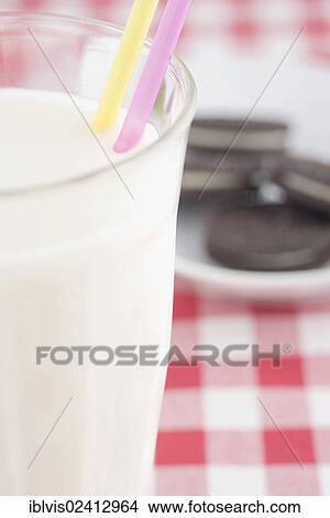 Chocolate cookies with vanilla cream filling and a glass of milk View Large Photo Image Picture - Chocolate cookies with vanilla cream filling and a glass of milk. Fotosearch