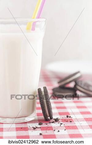 Chocolate cookies with vanilla cream filling and a glass of milk View Large Photo Image Stock Image - Chocolate cookies with vanilla cream filling and a glass of milk. Fotosearch