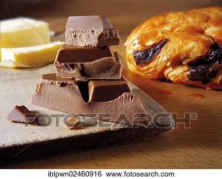 Stock Photograph - Chocolate pieces next to a chocolate croissant. Fotosearch