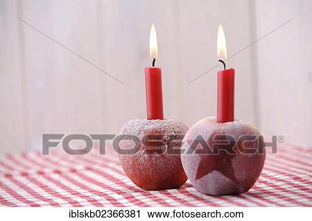 Stock Image - Christmas ambience with red apples and candles. Fotosearch