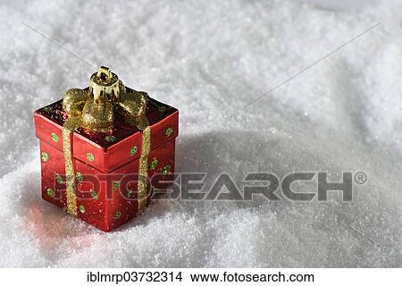 Picture - "Christmas decoration, Christmas ornament in the form of a present on snow". Fotosearch