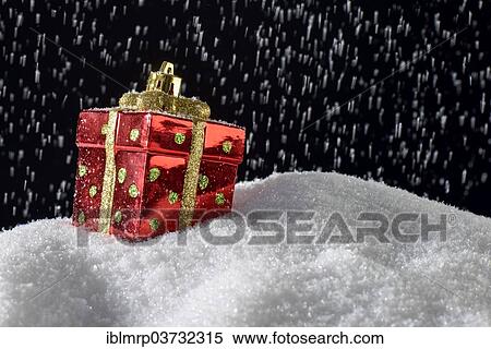 Stock Photography - "Christmas decoration, Christmas ornament in the form of a present on snow during smowfall". Fotosearch