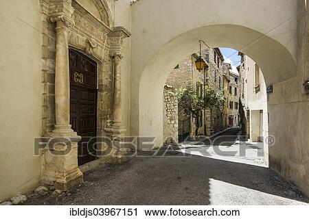 Stock Image - "Church portal and alleyway, Buis-les-Baronnies, Drome, Rhone-Alpes, Provence, France, Europe". Fotosearch