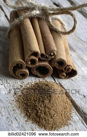 Stock Photograph - Cinnamon sticks and ground cinnamon on wooden boards. Fotosearch