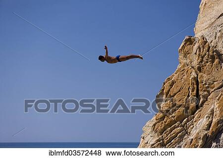 Stock Photo - "Clavadista or cliff diver jumping off the cliffs of La Quebrada, Acapulco, Guerrero, Mexico, North America". Fotosearch