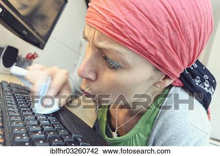 Stock Image - "Cleaning lady cleaning a computer keyboard, Germany, Europe". Fotosearch