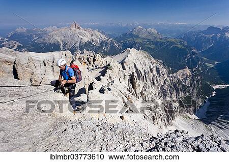"Climber on the Via Ferrata Marino Bianchi at Mt Monte Cristallo, Mt Croda Rossa or Hohe Gaisl at back, Dolomites, Belluno, Italy, Europe" View Large Photo Image Stock Image - "Climber on the Via Ferrata Marino Bianchi at Mt Monte Cristallo, Mt Croda Rossa or Hohe Gaisl at back, Dolomites, Belluno, Italy, Europe". Fotosearch