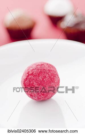 Closeup of a red chocolate truffle on a white plate View Large Photo Image Stock Photograph - Closeup of a red chocolate truffle on a white plate. Fotosearch