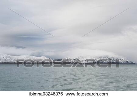 Stock Photograph - "Cloud-shrouded, snow-covered mountains, Smeerenburgfjorden, Spitsbergen Island, Svalbard Archipelago, Svalbard and Jan Mayen, Norway, Europe". Fotosearch