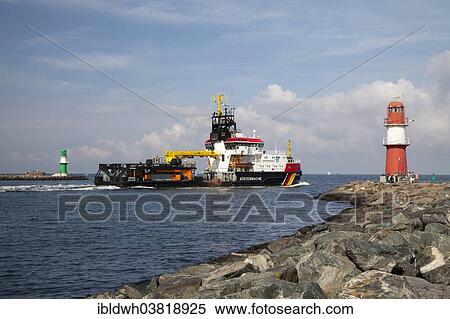 Stock Photography - "Coast Guard vessel passing two lighthouses at the harbor entrance, Warnemuende, Rostock, Mecklenburg-Vorpommern, Germany, Europe". Fotosearch