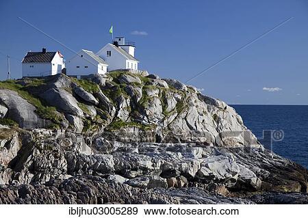 Stock Photo - "Coastal cliffs and the lighthouse, Henningsvaer, Henningsvaer, Heimoya, Heimoya, Lofoten, Nordland, Northern Norway, Norway, Europe". Fotosearch