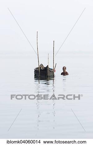 Picture - "Cockle picker at his boat, Vembanad Lake, Kerala, India, Asia". Fotosearch