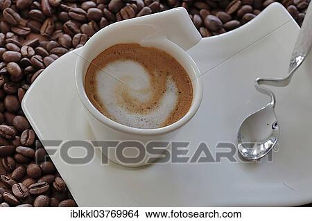 Picture - Coffee with frothed milk on coffee beans. Fotosearch