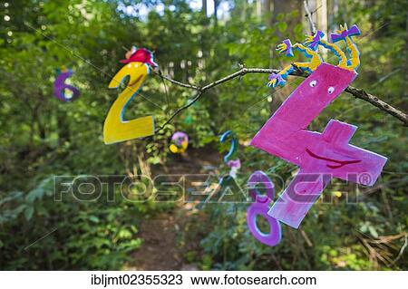 Stock Image - "Colorful numbers hanging in the trees, in the so-called number land at the forest kindergarten, Ilmmuenster, Bavaria, Germany, Europe". Fotosearch