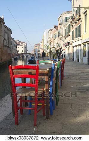 Stock Image - "Colourful chairs of a street cafe on the Rio de la Misericordia, Cannaregio, Venedig, Venezia, Veneto Region, Italy, Europe". Fotosearch