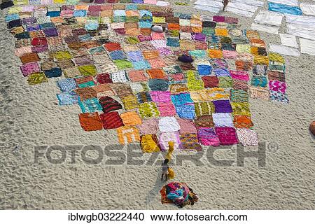 Stock Image - "Colourful saris laying to dry after washing on a sandbank on the banks of the Yamuna River, Yamuna, Agra, Uttar Pradesh, India, Asia". Fotosearch