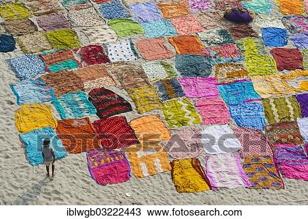 Stock Image - "Colourful saris laying to dry after washing on a sandbank on the banks of the Yamuna River, Yamuna, Agra, Uttar Pradesh, India, Asia". Fotosearch